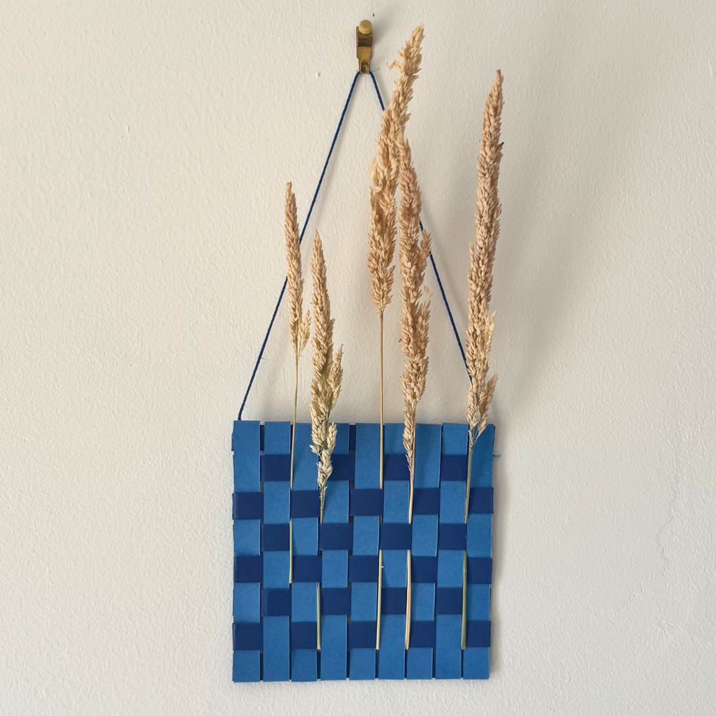 Tissage en papier réalisé à partir de bandelettes pour créer une décoration éphémère dans laquelle piquer des herbes sèches en été