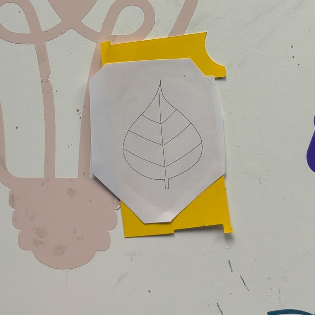 Etape 3 du tuto pour créer un DIY autour de l'automne avec des feuilles en papier glissées entre les livres d'une bibliothèque