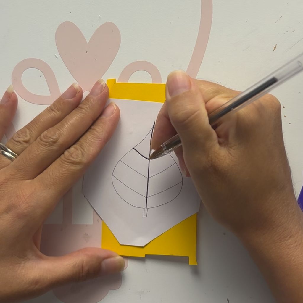 Etape 4 du tuto pour créer un DIY autour de l'automne avec des feuilles en papier glissées entre les livres d'une bibliothèque