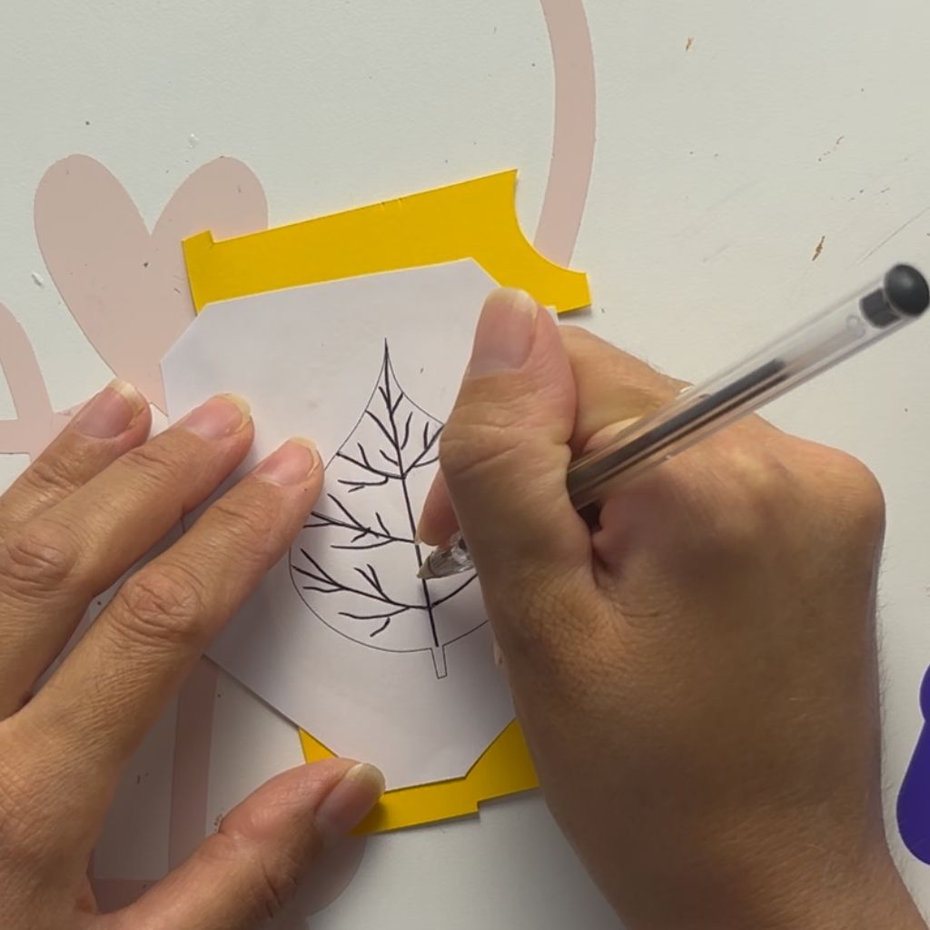 Etape 5 du tuto pour créer un DIY autour de l'automne avec des feuilles en papier glissées entre les livres d'une bibliothèque