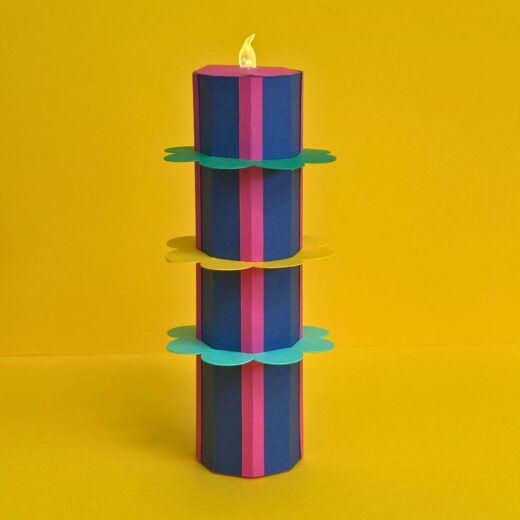Objet déco en papier 2 en 1 sous forme d'un bougeoir surmonté d'une bougie LED et décoré de collerettes en papier coloré