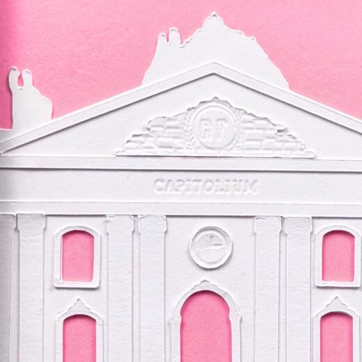Détails du Capitole créé par superposition de couches de papier blanc sur un fond rose vif.